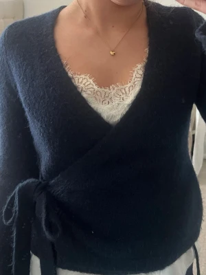 Mörkblå omlottkofta från Gina Tricot - Mysig mörkblå stickad omlottkofta från Gina Tricot med knytband i sidan 