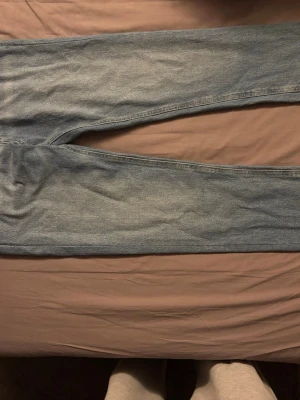 Ljusblå jeans från Jack & Jones - Säljer ett par ljusblå jeans från Jack & Jones med relaxed fit och raka ben. Klassisk femficksmodell i mjukt denimtyg, perfekta för en avslappnad stil. Passar dig som gillar enkel och tidlös look.