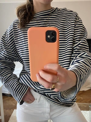 Randig långärmad tröja i bomull - Säljer en snygg långärmad tröja med marinblå och vita ränder. Tröjan har en avslappnad passform och rund halsringning. Perfekt för dig som gillar klassisk stil och mjuka material. Materialet är bomull och den är riktigt skön att bära.