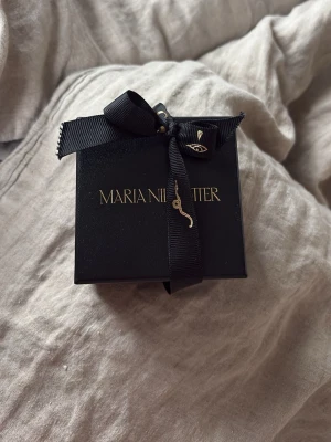 Silverörhänge från Maria Nilsdotter - Säljer ett coolt örhänge från Maria Nilsdotter i silverfärg. Örhänget har en unik design med två ringar och en spetsig hängande detalj. Kommer i original ask med svart rosett och gulddetaljer. Perfekt för dig som gillar edgy accessoarer. Pris går att diskutera 