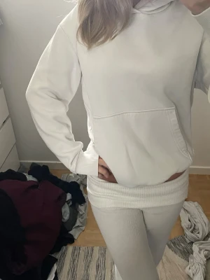 Vit oversized hoodie med huva - Säljer en vit oversized hoodie med huva och stor magficka. Hoodien har ribbade muddar vid ärmslut och nederkant, samt en avslappnad passform. Perfekt för dig som gillar en clean och enkel stil. Märke och material är ej angivet.
