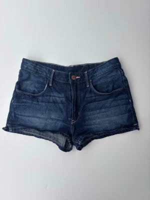 Mörkblå jeansshorts med normal passform - Klassiska mörkblå jeansshorts i bomull. De har en normal passform och är perfekta för varma dagar. Snyggt slitna detaljer och tidlös design som funkar till det mesta. Mid waist 