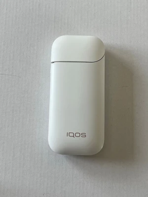 IQOS 2.4 Plus elektronisk tobaksenhet vit - IQOS elektronisk tobaksenhet i vit plast med tillhörande laddare, USB-kabel och rengöringsverktyg. Smidig och modern design, perfekt för dig som vill ha ett alternativ till traditionella cigaretter. Allt du behöver för att komma igång med IQOS finns med. Använt, men fungerar bra och håller batteritiden
