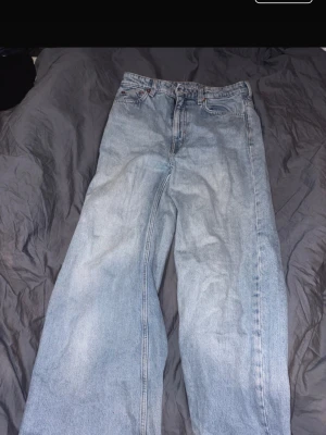 Ljusblåa wide leg jeans - Säljer ett par ljusblåa jeans med breda ben och hög midja. Klassisk femficksmodell i mjukt denimtyg, perfekt för en avslappnad och trendig look. Passar dig som gillar vintage vibe och loose fit.