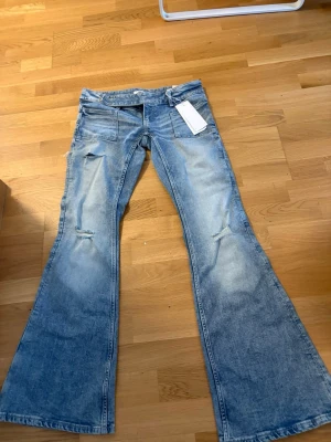 Ljusblå utsvängda jeans Gina tricot - Säljer ett par helt nya oanvända ljusblå jeans från Gina tricot med utsvängda ben och slitningar vid knäna. Jeansen har klassisk femficksmodell och är tillverkade i bomull med en snygg tvättad look. Perfekta vardagsjeans eller om man vill ha en lite snyggare outfit!💗 storlek M