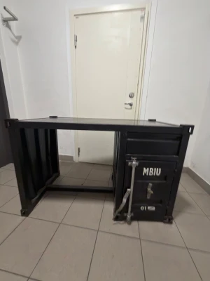 Skrivbord i containerstil svart metall ”snabb äffar”!!! - Unikt skrivbord i svart metall med industriell containerdesign. Ena sidan har ett skåp med lås och handtag, samt texten 'MBIU' på dörren. Perfekt för dig som gillar rå och modern inredning. Bordet har robust konstruktion och tydliga detaljer från containerestetiken.