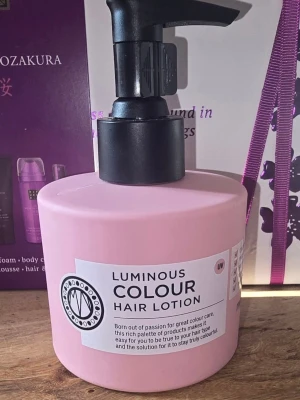 Luminous Colour Hair Lotion - Ljusrosa pumpflaska med Luminous Colour Hair Lotion från Maria Nila. Hårkrämen är framtagen för färgat hår och innehåller UV-skydd. Flaskan är rund och har en svart pump, perfekt för enkel dosering.