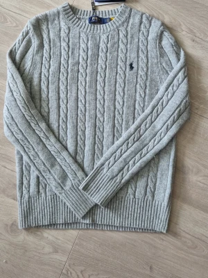Polo Ralph lauren tröja - Tja! Säljer min polo ralph lauren tröja. Den är helt oanvänd alltså ny, lapp finns kvar. Den är i storlek S och i färgen grå. Denna stiliga stickade tröjan är perfekt nu inför sommaren. 