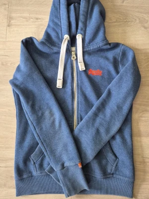 Super dry zip hoodie - Säljer min superdry hoodie i storlek S. Är i färgen blå och är i ett riktigt bra skick.