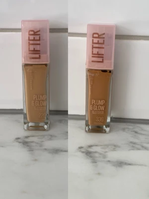 Maybelline Plump & Glow Foundation - Två flaskor Maybelline Plump & Glow foundation med rosa lock och texten 'Lifter' på locket. En flaska i nyansen 220 och en i nyansen 336. Glasflaskor med rektangulär form, flytande foundation som ger glow och plump-effekt.