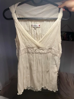 Vit omlottopp blusaktig - Säljer en vit omlottopp, lite blusaktig från Monnari med v-ringning och knyt på axlarna. Toppen har en markerad midja och är tillverkad i ett tunt material som ger en flowy känsla. Perfekt för sommaren och enkel att styla med jeans eller kjol. Står storlek M men passar mig med XS