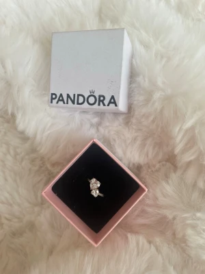 Guldring med dubbelhjärtan från Pandora - Snygg guldring från Pandora med glittrande hjärtan och stenar i mitten och på sidorna. Ringen har en elegant och modern design som verkligen sticker ut. Perfekt accessoar för att lyfta vilken outfit som helst. Pris kan diskuteras.