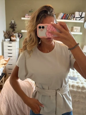 T-shirt med bälte - Cool T-shirt från Zara med bälte! Färgen är typ lite krit grå/begie!💖❤️‍🔥Endast använd 1 gång! 