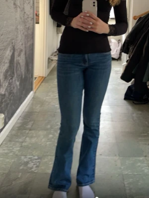 Lågmidjade bootcut jeans Gina - Säljer dessa sjukt snygga jeansen från Gina då de inte längre kommer till användning. De är lågmidjade med bootcut modell och silvriga knappt på bakfickorna. De är använda men i riktigt bra skick och har inga defekter. Hör av er om ni har frågor!🩷