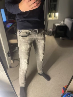 Grå slim Replay jeans  - Säljer ett par grå slim fit jeans med snygga slitningar och tvättad look. Jeansen har klassisk femficksmodell och normal midja. Perfekta för dig som gillar en trendig och avslappnad stil. Från Replay 