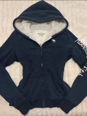 Marinblå hoodie från Abercrombie & Fitch - Snyggaste zip hoodien🔥🔥 Står storlek L men passar mig som vanligtvis har xs/s! Köpt för 2500