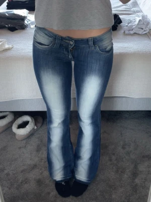 Blå bootcut jeans från Cheap monday - Säljer ett par blå lågmidjade bootcut jeans från cheap monday. Har spretat upp dom längst ner så de ska bli längre, storlek 26/32. Säljer då de Inte är min stil längre