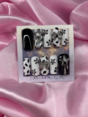 Milk (M);Medium Square - Snygga handgjorda press-on naglar i svart och vitt. Naglarna har coolt ko-mönster, 3D silverrosetter och stjärndekorationer. Medium långs och square i formen, perfekta för dig som vill sticka ut. Gjorda i  M: 16 mm, 12 mm, 12,5 mm, 11,5 mm, 10 mm.