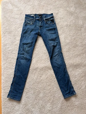 Replay Anbass W28 L32 - Snygga Replay jeans i modellen Anbass, storlek 28 i midjan och 32 i längd. Relativt använda, nypris ca 1600kr. Bara att skriva vid ytterliggare funderingar.