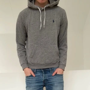 Grå Ralph Lauren Hoodie - Säljer en sjukt nice grå hoodie från Ralph Lauren. Hoodien är i strl M men sitter som S, den är även i bra skick och hör gärna av er vid frågor elr funderingar!!