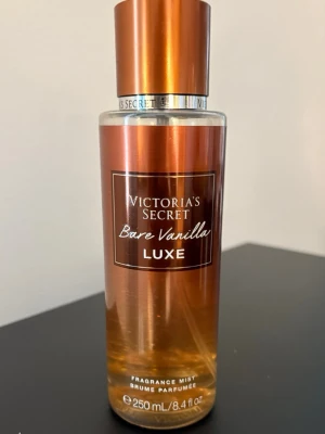 Victoria's Secret Bare Vanilla Luxe mist - En lyxig body mist från Victoria's Secret i doften Bare Vanilla Luxe. . Innehåller 250 ml och har en praktisk sprayfunktion. Perfekt för dig som älskar varma, söta vaniljtoner. Se markering för hur mkt kvar. Mer än hälften 