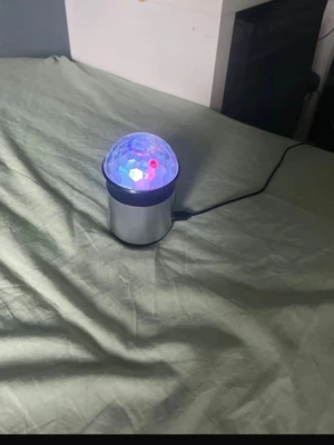 Trådlös högtalare med LED-ljus - Cool trådlös högtalare i silver med rund form och inbyggd LED-lampa som lyser i flera färger. Högtalaren har ett transparent kupolformat lock med mönster som sprider ljuset snyggt. Perfekt för att skapa stämning med både musik och ljuseffekter.