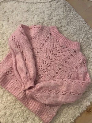 Rosa stickad tröja med hålmönster💘 - Superfin rosa stickad tröja med snyggt hålmönster och breda ribbade muddar vid ärmslut och nederkant. Storleken är M men sitter som en S