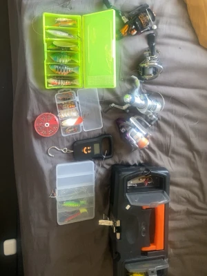 En rulle för 100kr en låda med drag 50kr allting 600kr säg till vad ni ska ha  - Säljer ett komplett fiskeset med flera fiskedrag i olika färger och former, tre fiskerullar, digital våg, linor och en robust svart-orange fiskelåda. Perfekt för dig som vill ha allt samlat för fisketuren. Allt är organiserat i praktiska askar.