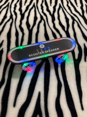 Scooter Speaker med LED-ljus - En högtalare med hyfsat bra ljud för storleken! Form av en skateboard (laddare följer ej med/kan köpas med)! Hör av dig vid minsta fundering 