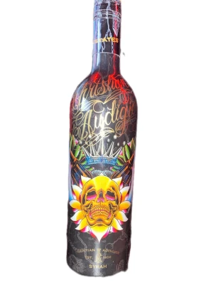 Christian Audigier Ed Hardy Vinflaska - Unik vinflaska från Christian Audigier med färgstark design, dödskallemotiv och detaljer i guld, rött och blått. Flaskan är av glas och har tryckt text och illustrationer runtom. Perfekt som samlarobjekt eller dekoration. Kan träffas upp i Stockholm och priset kan diskuteras