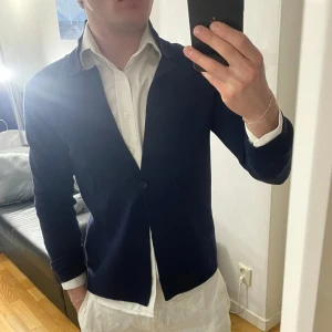 Mörkblå cardigan från Signal XS - Mörkblå cardigan från Signal i stickat material. Klassisk design med krage, en knapp framtill och lång ärm. Perfekt för dig som gillar en clean och stilren look. Passar till skjorta eller t-shirt för en chill men uppklädd vibe. Storlek XS, bra skick.