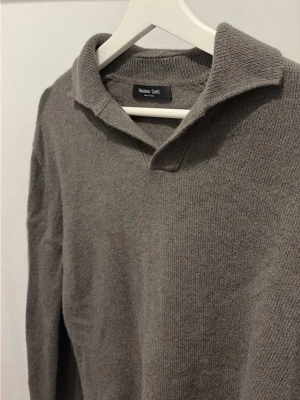 Grå stickad tröja från Massimo Dutti - Snygg grå stickad tröja från Massimo Dutti med krage och lång ärm. Perfekt för lager på lager och enkel att matcha med olika stilar. OBS: Orginalstorlek är M men krympte i första tvätten, så nu är det en S! ANVÄND ENDAST 1 GÅNG. Nypris: 900kr