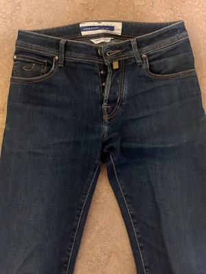 Mörkblå jeans - Snygga mörkblå jeans med slim passform och klassiska kontrastsömmar. Jeansen har fem fickor och är tillverkade i ett mjukt denimtyg som ger en bekväm känsla. Perfekta för dig som gillar en tidlös och avslappnad stil. Model nick, Jacob cohen