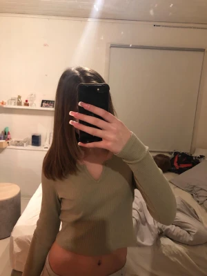 Ljusgrön ribbad croppad topp - Trendig ljusgrön croppad topp med lång ärm och v-ringning. Ribbad struktur ger en snygg och bekväm passform. Perfekt att styla med höga jeans eller kjol för en cool vardagslook.