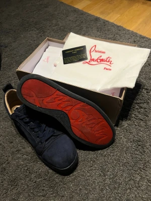 Mörkblåa  sneakers från Christian Louboutin - Mörkblåa sneakers från christian Louboutin i bra skick använda endast några få gånger.