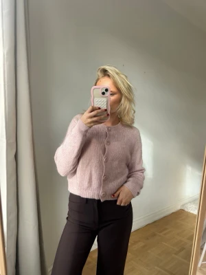 Ljuslila stickad kofta med knappar💖💖 - Mysig ljuslila stickad kofta med stora matchande knappar framtill. Koftan har en rak, något boxig passform och långa ärmar. Perfekt för lager på lager och ger en soft vibe till din outfit.