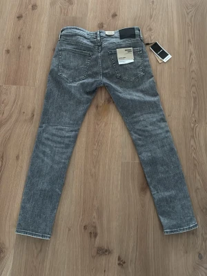 Ljusgråa jeans från JJ  - Säljer ett par grå jeans med lite slitningar som jag aldrig har använt prisförslag kan jag gå med på vid snabbköp.