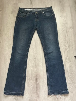Blå bootcut jeans med broderad ficka - Säljer ett par blå bootcut jeans med snyggt broderi i gult på bakfickan. Super snygga men tyvärr för små.