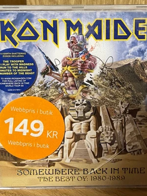Iron Maiden: Somewhere Back in Time CD - Iron Maiden: Somewhere Back in Time - The Best of 1980-1989. Samlingsalbum med ikoniskt omslag i blått, gult och brunt med egyptiskt tema och bandets maskot Eddie. Perfekt för dig som gillar hårdrock och klassiska album.