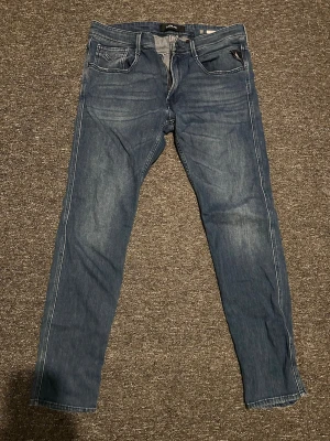 Replay anbass jeans - Snygga blå jeans från replay sen har ljusa slitningar framtill och bakficka med dekorativ söm. Tillverkade i mjukt denimtyg som ger en avslappnad look.