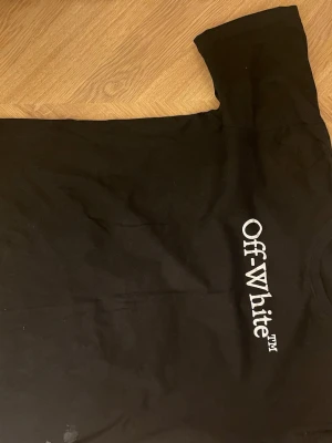 Svart Off-White t-shirt med logga - Snygg svart t-shirt från Off-White med den klassiska loggan tryckt i vitt på bröstet. T-shirten har rund hals och korta ärmar. Tillverkad i mjuk bomull som känns skön mot huden. Perfekt för dig som gillar streetwear och vill ha något stilrent.
