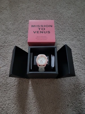 Omega x Swatch Mission to Venus - Säljer en Omega x Swatch Speedmaster MoonSwatch Mission to Venus. Klockan har en ljusrosa boett i biokeramik, vit urtavla med tre subdials och vit rem med Omega-logga. Snygg och unik design som sticker ut på handleden.