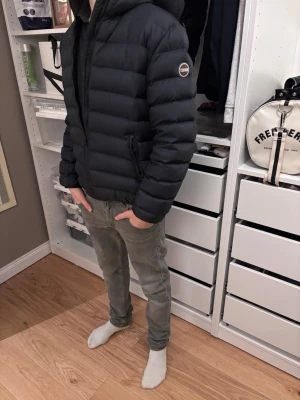 Colmar jacka  - Säljer en svart dunjacka från Colmar med huva och dragkedja framtill. Jackan har en puffig design, två sidofickor med dragkedja och Colmar-logga på ärmen. Perfekt för kalla vinterdagar och riktigt skön att bära.  Storlek xs men passar S bättre