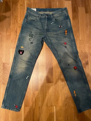 Gucci blå jeans med broderade detaljer - Unika blå jeans från Gucci med broderade patchar. Nyskick då dom använts 4 gånger. Nypris 790 EUR ~ 8500 kr. Se storleksguide enligt storlek S. Pris kan diskuteras vid snabb affär 