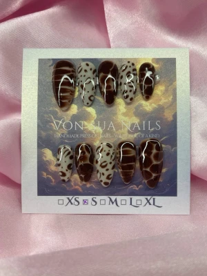 Feral (S); Medium Almond - Handgjorda press-on naglar i storlek S: 15 mm, 11,5 mm, 12 mm, 11 mm, 9 mm. Setet har coola bruna och beiga mönster med både leopardfläckar och trendiga handmålade mönster. Naglarna är medium långa och mandelformade.