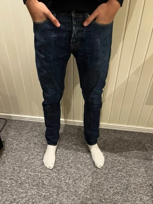 Mörkblå raka jeans från indigo - Säljer ett par mörkblå jeans med rak passform och klassiska fem fickor. Jeansen har snygga slitningar och kontrastsömmar. Perfekta till en avslappnad stil och passar till det mesta. Materialet är denim i bomull.