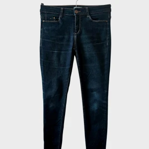 Mörkblå skinny jeans med dragkedja - Mörkblå skinny jeans från ESPRIT med klassisk femficksdesign och snygga kontrastsömmar. Jeansen har dragkedja vid benslut för en cool detalj. Stretchigt denimtyg som sitter tight och bekvämt. Perfekta till sneakers eller boots.