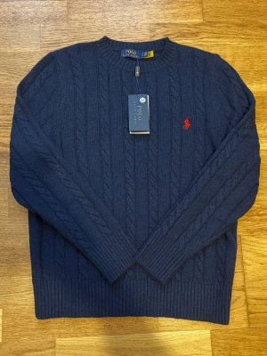 Mörkblå Stickad tröja Polo Ralph Lauren - Kabelstickad mörkblå tröja från Polo Ralph Lauren i storlek M. 😎 Priset kan diskuteras 💯(skicka gärna bud).