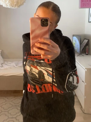Svart hoodie med racingtryck - Säljer denhär jätte fina tröjan med tryck fram bak och på armen. Använd kanske 3 ggr så ny skick. I storlek s 