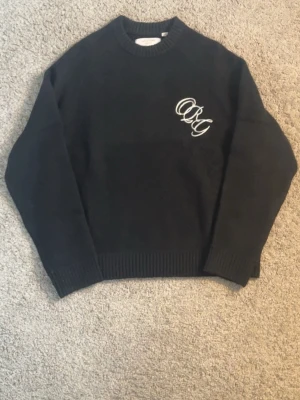 Jack & Jones stickad tröja herr S svart polyester - Jack & Jones stickad tröja för herr i storlek S. Tröjan är svart och tillverkad i polyester. Rund halsringning med ribbad mudd vid hals, ärmslut och nederkant. Diskret broderad/logotypdetalj på bröstet. Passar som vardagströja eller som extra lager vid kyligare väder.